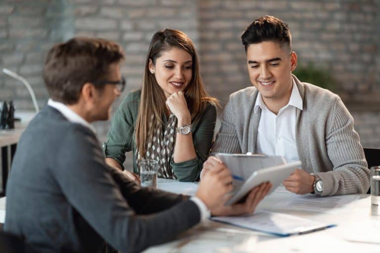 young happy couple having consultations with bank manager meeting office